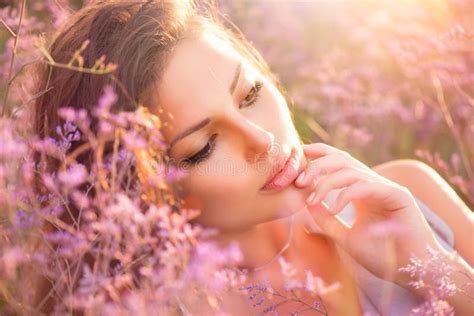 Belle Jeune Femme Se Trouvant Sur Le Champ En Herbe Verte Et Fleurs De