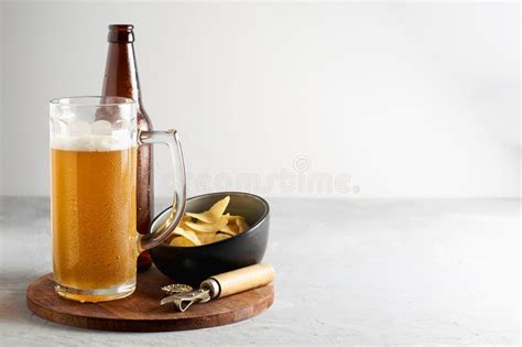 Cerveza De Cerveza Dorada En Vidrio Y Botella Con Las Patatas Fritas