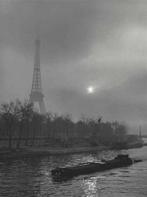 The Eiffel Tower Towering Over The City Of Paris On A Foggy Day