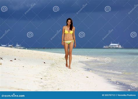 Ragazza In Bikini Giallo Che Cammina Sulla Spiaggia Bianca Sotto Il Cielo Della Tempesta