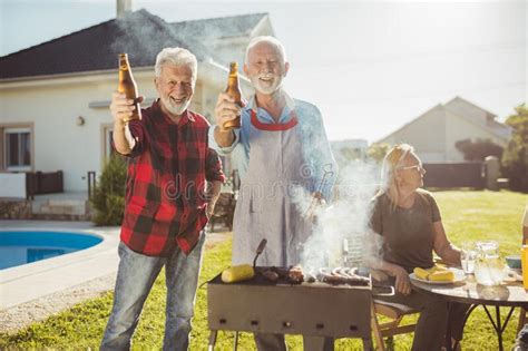 Gente Mayor Haciendo Un Brindis Mientras Tienen Barbacoa En El Patio