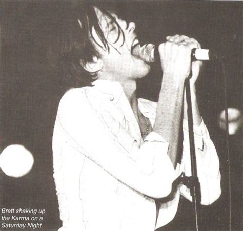 A Black And White Photo Of A Person On Stage With A Microphone In His Hand