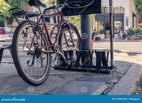 Bicycle Parked In A Bicycle Rack In A Corner Of The Sidewalk Stock