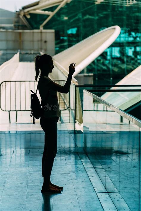 Silueta Contra La Luz De La Mujer Joven Que Toma Las Fotos Imagen De