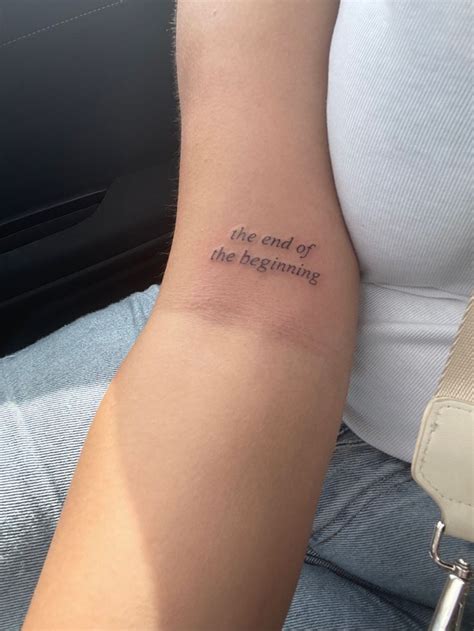 A Person With A Tattoo On Their Arm That Says The End Of The Beginning