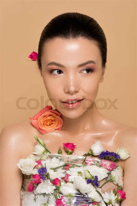 Attractive Naked Asian Girl In Fresh Flowers Isolated On Beige Stock