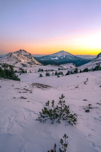 Belas paisagens de altas montanhas rochosas cobertas de neve sob um céu