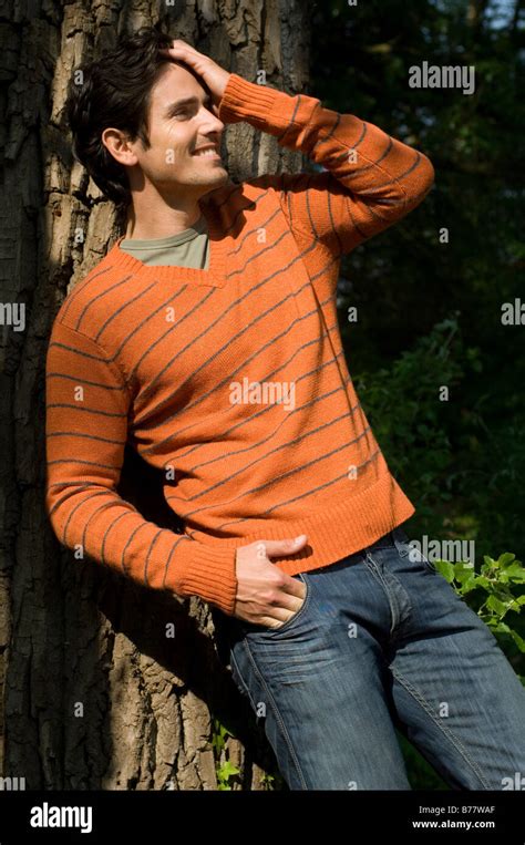 Man Leaning Against A Tree Stock Photo Alamy