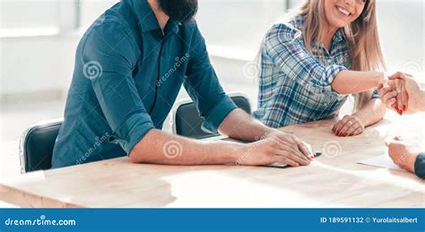 Group Of Successful Young People Sitting At The Negotiating Table