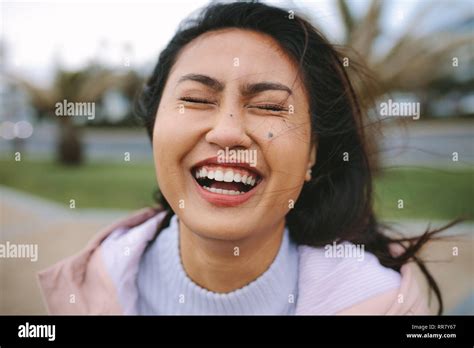 Portrait Of A Woman Standing Outdoors And Laughing Close Up Of An