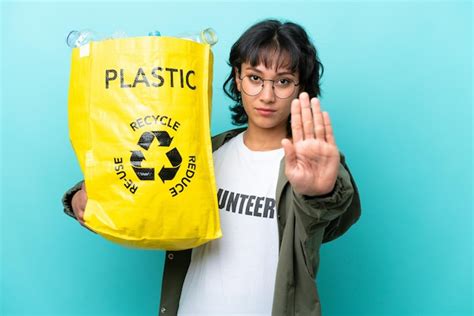 Joven argentina sosteniendo una bolsa llena de botellas de plástico