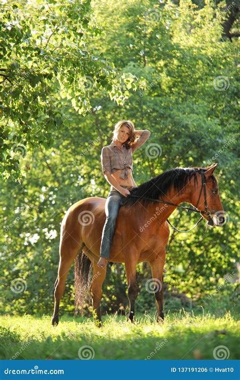 Beautiful Model Girl Rides With Horse In Woods Glade At Sunset Stock