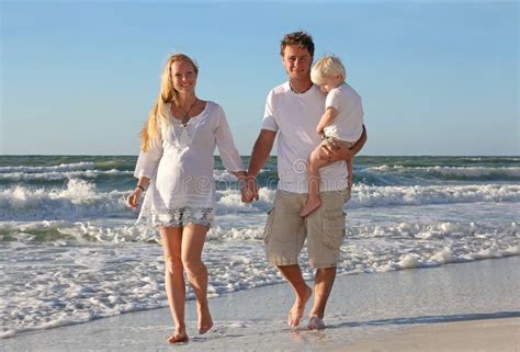 Familia Feliz De Tres Personas Que Caminan En La Playa A Lo Largo Del