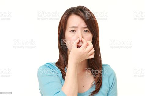 Japanese Woman Holding Her Nose Because Of A Bad Smell Stock Photo