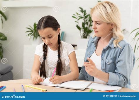 Une Mère Aidant Sa Fille Avec Des Devoirs Photo stock Image du soin