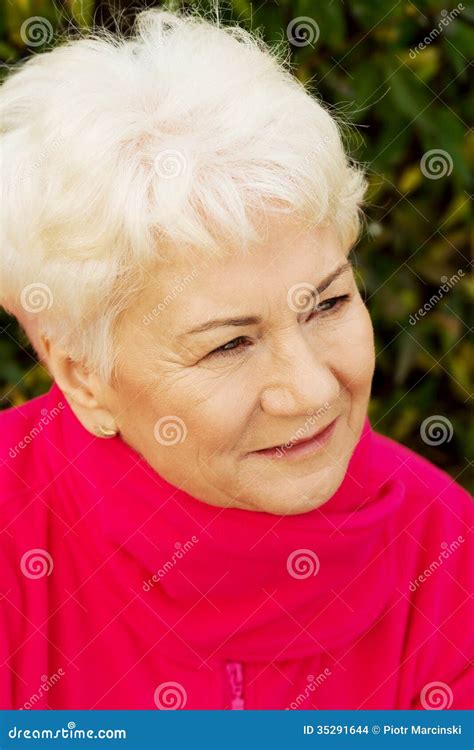 Portrait Of A Cheerful Old Lady Over Green Background Stock Photo