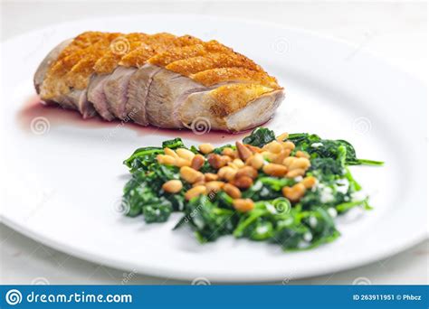 Roasted Duck Breast Served With Salad Of Spinach Leaves And Pine Nuts