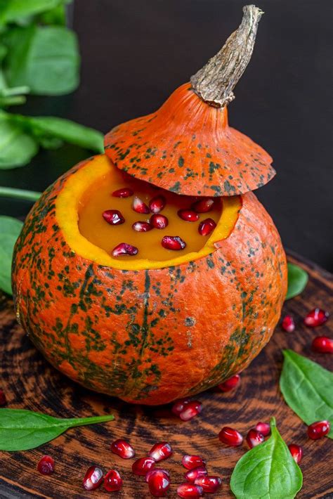 Closeup Of Yummy Pumpkin Halloween With Pomegranate In Fresh Spinach