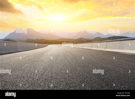 Empty Asphalt Road And Mountains With Beautiful Clouds At Sunset Stock