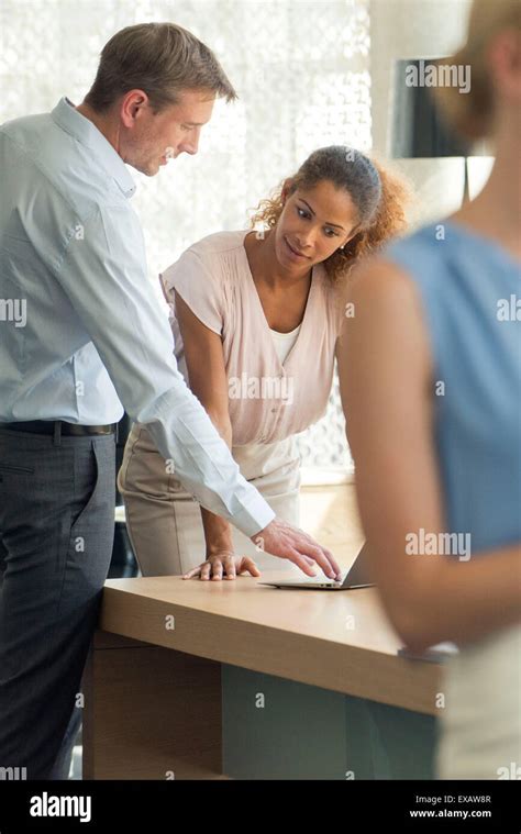 Salesman demonstrating laptop computer for customer Stock Photo - Alamy