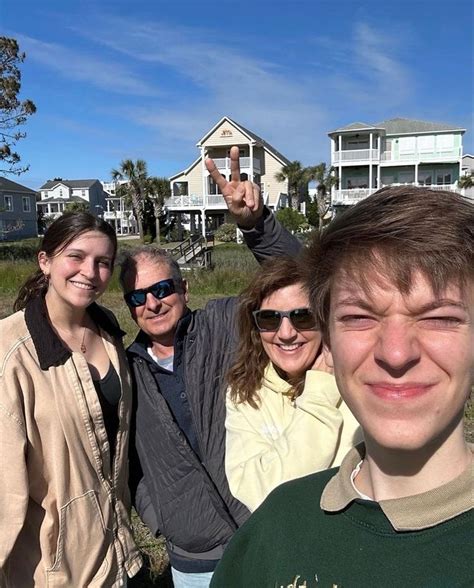 A Group Of People Standing Next To Each Other In Front Of Some Houses