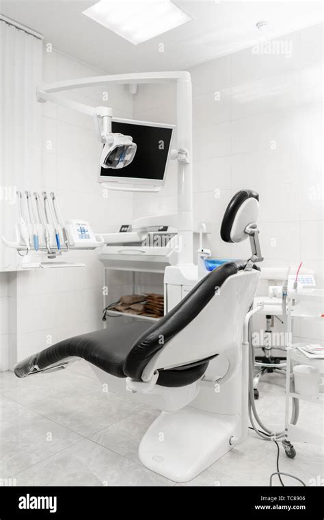 Vertical view of a dentist room with black seat. Modern dental practice ...