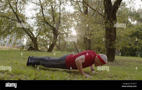 Active senior elderly 80 years old caucasian man doing morning push-ups ...