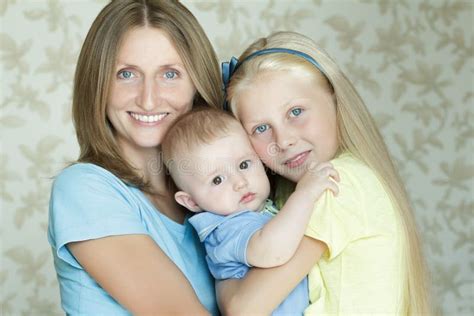 Familia De Retrato Interior Sonriente Y De Abrazo De Tres De La Gente