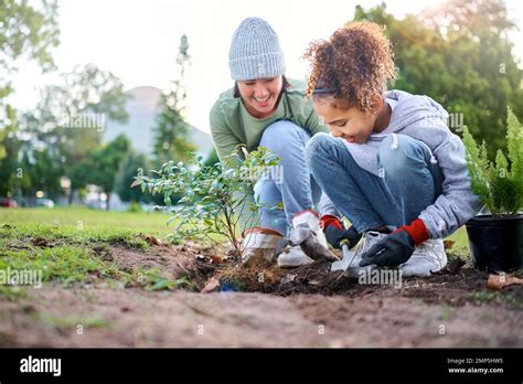 Voluntario niño y mujer con la planta para la jardinería en el parque