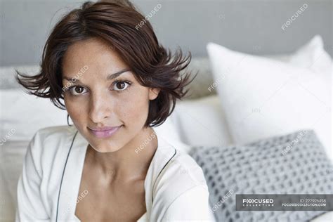 Portrait Of Brunette Woman Sitting On Bed Head And Shoulders Home Stock Photo 222926458