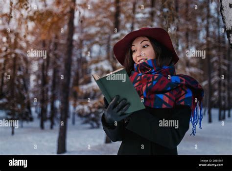 A Beautiful Mature Woman Reading A Book In Winter Park Stock Photo Alamy