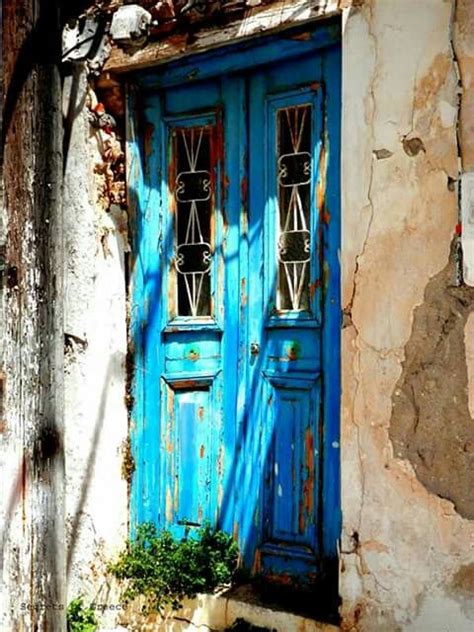 An Old Building With A Blue Door And Window