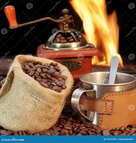 Stainless Steel Coffee Mug and Old Grinder with Beans Stock Photo