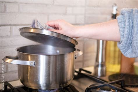 woman checking the pot on the stove boiling water Stock Photo | Adobe Stock