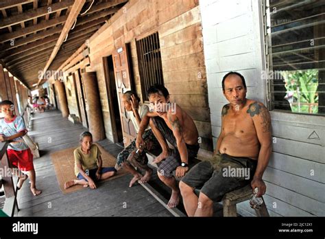 People Having A Relax Time At The Porch Of The Longhouse Of Traditional