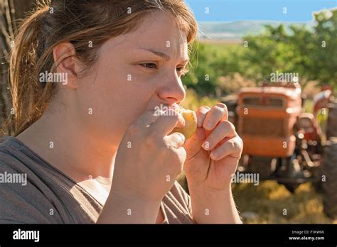 Blonde Girl Eat Fruit In Farm Stock Photo Alamy