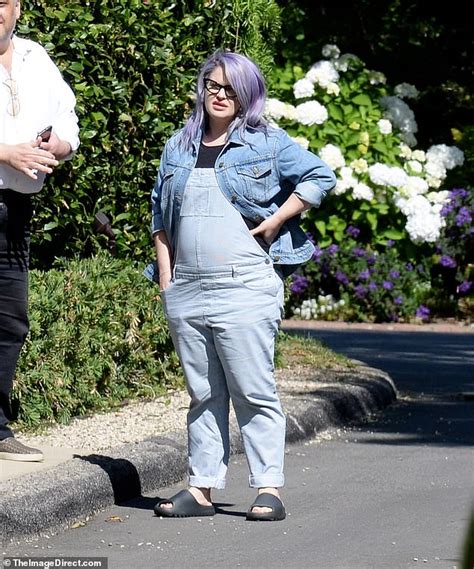 Kelly Osbourne shows off her growing baby bump in denim overalls ...