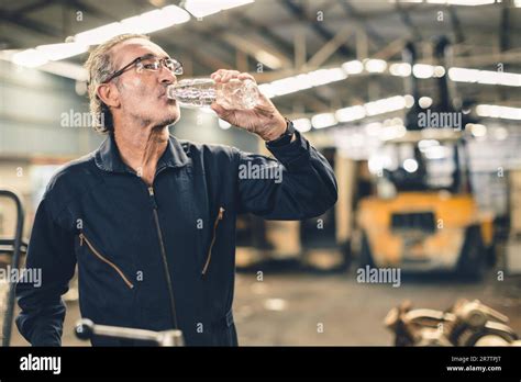 Thirsty Senior Male Staff Worker Drinking Water Refreshing From Tired Hard Work In Hot Workplace