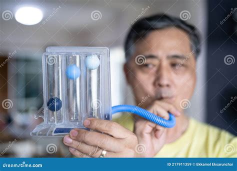 Old Man Uses A Tri Ball Incentive Spirometer For Check His Lung