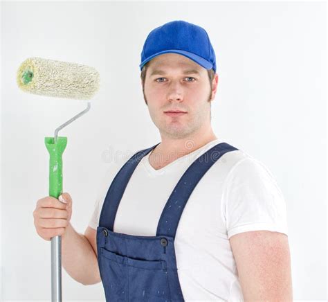 Painter In Uniform Holding Paint Roller While Standing Near Colleague