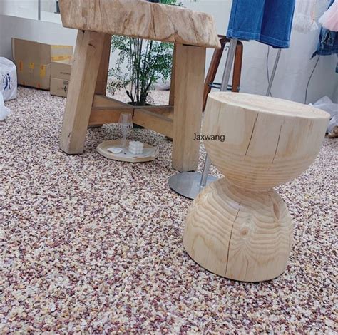 a wooden bench sitting on top of a floor next to a tree stump and other ...