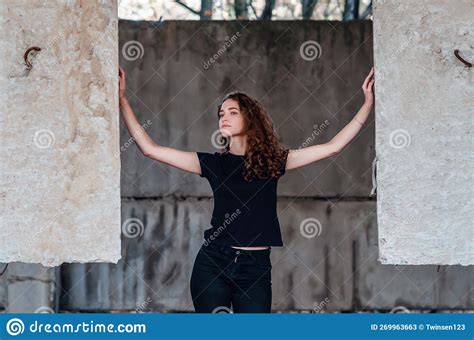 Dramatic Photo Of A Woman In An Abandoned Building Standing Among Concrete Structures Stock