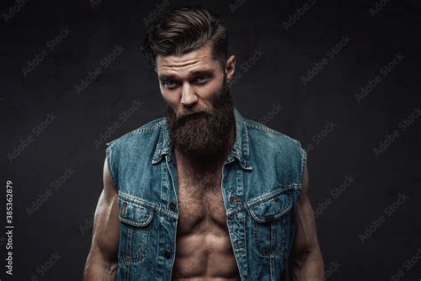 Muscular And Self Confident Guy With Naked Torso And Beard With Modern Haircut Posing In Dark