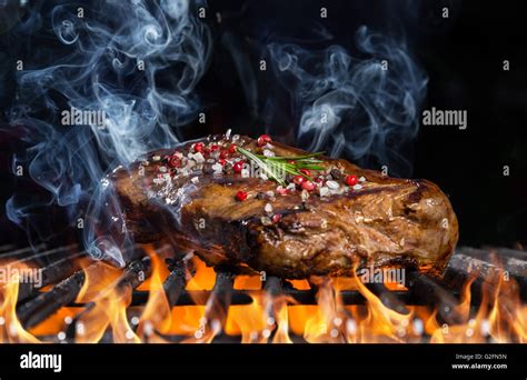 Beef Steak On Grill In Fire With Black Background Stock Photo Alamy