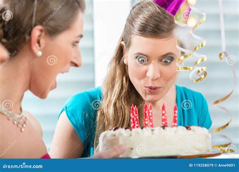 Young Woman Making a Funny Face while Blowing Out the Candles Stock ...