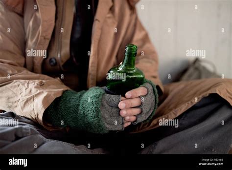 A Midsection View Of Homeless Beggar Man Sitting Outdoors Holding