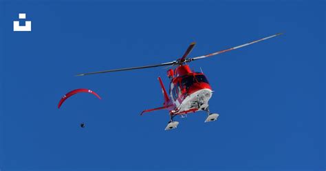 A Red And White Helicopter Flying Through A Blue Sky Photo Free