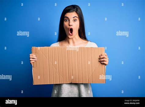 Jeune belle femme activiste brunette tenant une bannière en carton vierge protestant peur en