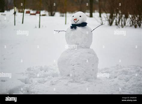 Big snowman with happy face, carrot nose and scarf on a winter day ...