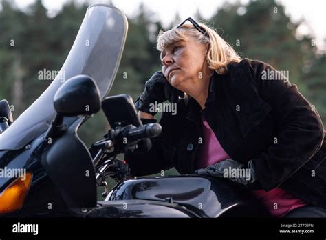Adult Dreams Of Something Blonde Female Motorcycle Tourist In Black Gloves Sitting On Her Bike